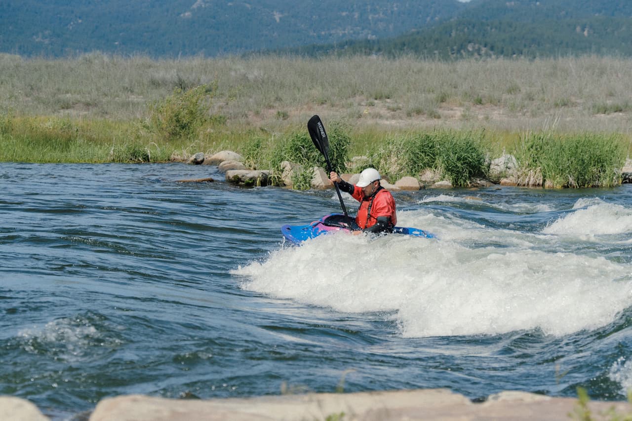 Kayaker surfing a wave at Kelly's Whitewater Park next to Birch Glen Lodge in Cascade, Idaho