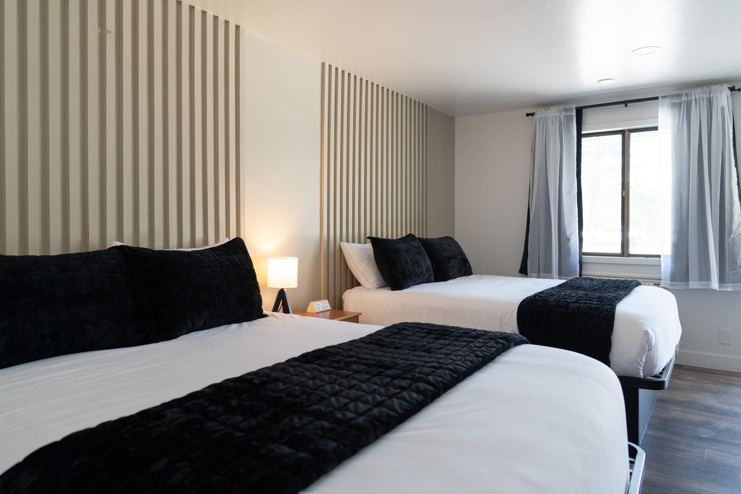 Guest room with two beds and slatted wood accent walls at Birch Glen Lodge in Cascade, Idaho