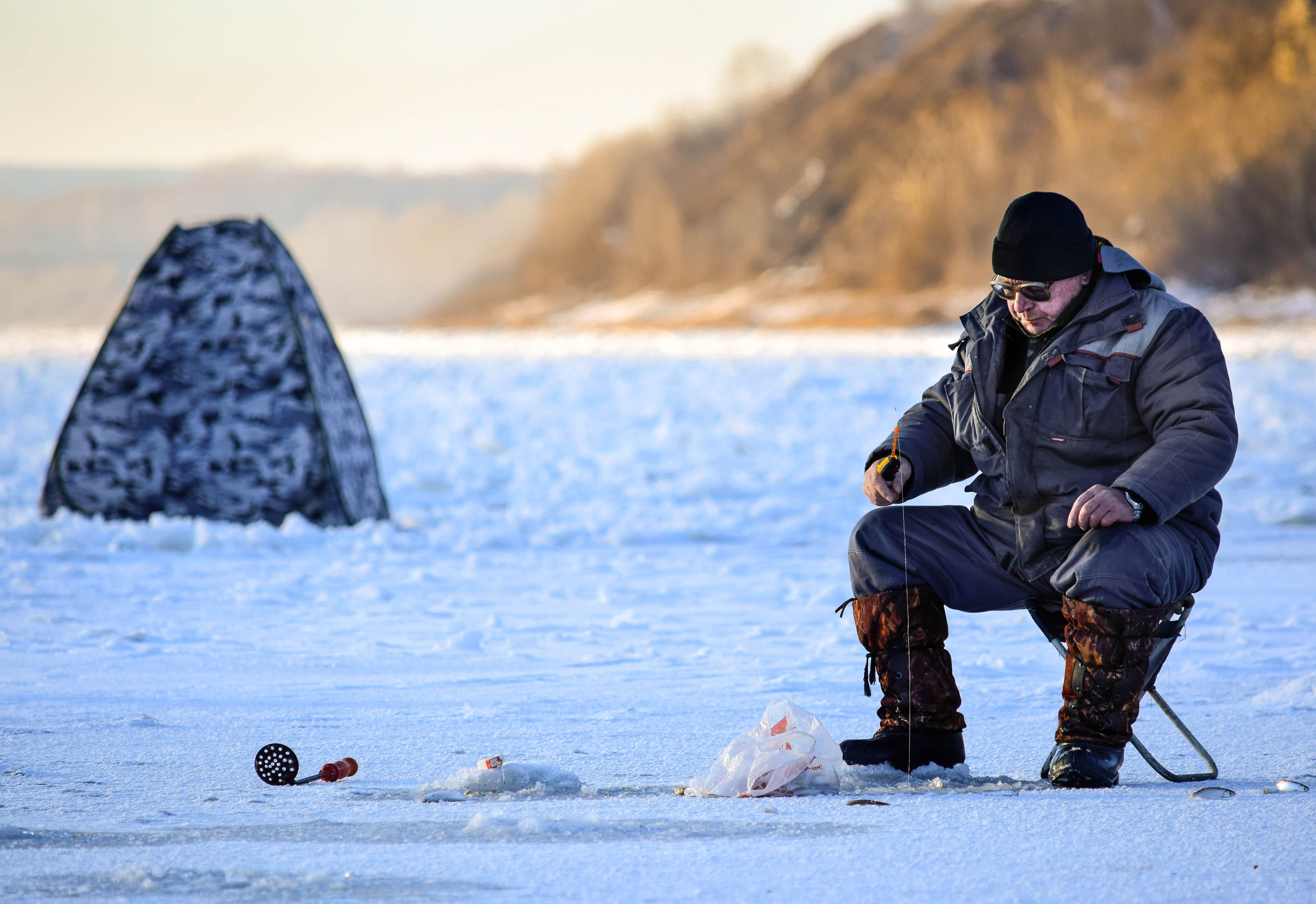 Angler ice fishing for jumbo perch on frozen Lake Cascade, Idaho